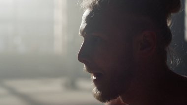 Spor salonunda duran ciddi bir adam. Atletik adam antrenmana hazırlanıyor.