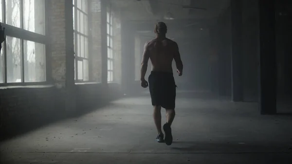 근육 운동 선수가 크로스 핏 헬스 장에서 걷고 있어요. 훈련을 위해 스포츠 클럽에 가는 남자 — 스톡 사진