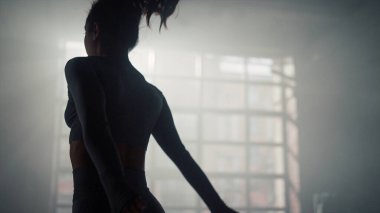 Modern spor salonunda atlayan aktif bir kız. Enerjik kadın zıplayarak çömeldi.