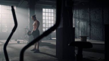 Halterle bisepsi pompalayan bir sporcu. Spor kulübünde kol egzersizi yapan adam.