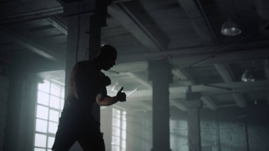 Çatı katında boks antrenmanı yapan atletik bir adam. Gölgelerle savaşan erkek boksör
