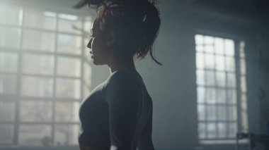 Sporcu kadın ip atlamakla kardiyo çalışması yapıyor. İp atlayan kız