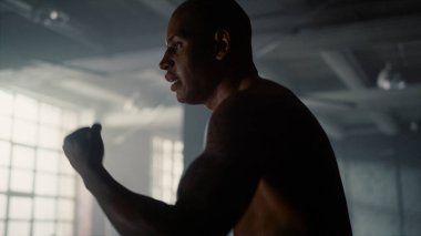 Kickboks antrenmanı sırasında gölgelerle kavga eden adam. Boksör savaşa hazırlanıyor