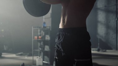 Koltuk değnekleriyle çömelen bir adam. Spor kulübünde ağırlık kaldıran erkek sporcu