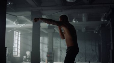 Beden eğitiminde kickboks yapan bir adam. Kardiyo antrenmanı sırasında yumruk talimi yapan adam.