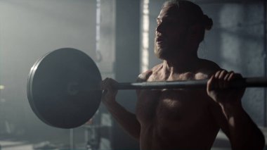 Adam halter kaldırıyor. Çapraz oturum sırasında egzersiz yapan erkek vücut geliştirici