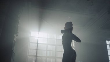 Kadın vücut geliştirici, omuz kaslarını esnetiyor. Ellerini ısıtan kaslı kadın. 