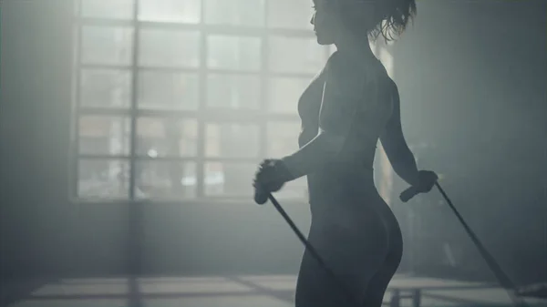 Chica en forma saltando con saltar la cuerda en el gimnasio. Atleta haciendo ejercicio sobre cuerda de salto —  Fotos de Stock