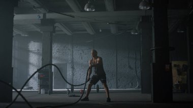 Savaş halatlarıyla vücut geliştirici eğitimi. İnsan güç egzersizleri yapıyor. 