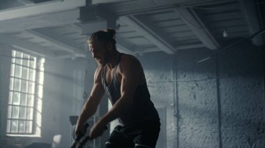 Adam savaş halatlarıyla spor yapıyor. Adam spor yapıyor.