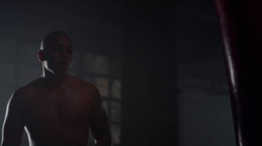 Spor salonunda yorgun adam boks torbası. Erkek boksör kardiyo çalışması yapıyor.