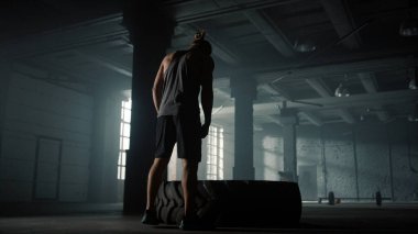 Lastik lastikle egzersiz yapmaya hazırlanan bir sporcu. Lastik patlatan adam.