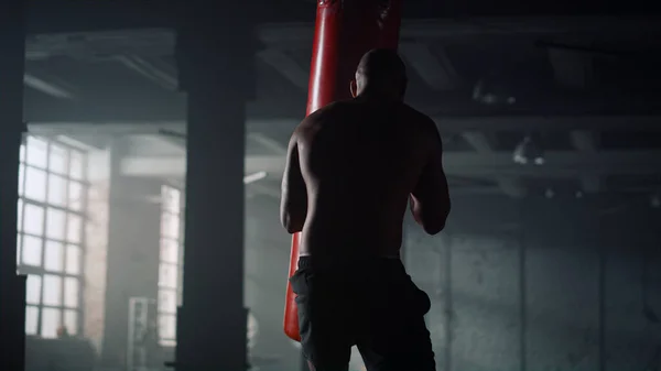 Boxeador saco deportivo de boxeo. Hombre fuerte trabajando golpes en saco de boxeo — Foto de Stock