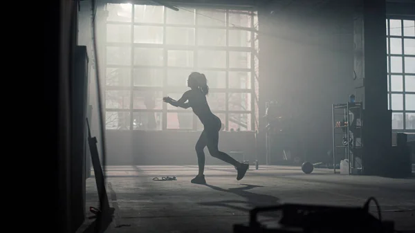 Sportowa dziewczyna kuca w nowoczesnej siłowni. Kobieta sportowiec robi przysiady z rzuty — Zdjęcie stockowe
