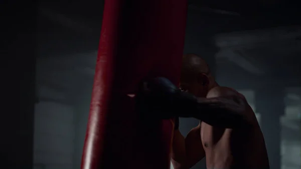 Um homem a praticar boxe num clube de luta. Lutador masculino praticando chutes — Fotografia de Stock