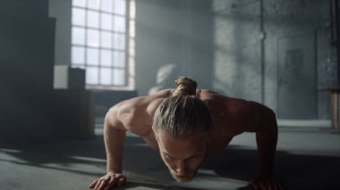 Spor salonunda şınav çeken bir sporcu. Adam çatı katında fitness eğitimi alıyor.