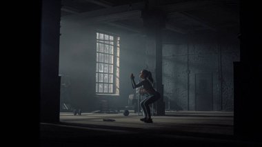 Çömelme hareketleri yapan bir kadın. Sportif kız antrenman sırasında mekik çekiyor.