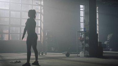 Eğitimden sonra elleri ısıtan vücut geliştirici. Çalışmadan önce ellerini hareket ettiren kadın