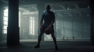 Çatı katında basketbol eğitimi alan bir adam. Zıplayan basketbol topu