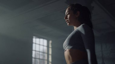 Bir kadın beden eğitimi dersinden önce vücudunu esnetiyor. Kız el kaldırıyor.