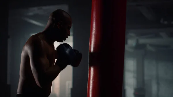 Erkek boksör kum torbasıyla dövüşüyor. Dövüş müsabakasına hazırlanan adam — Stok fotoğraf