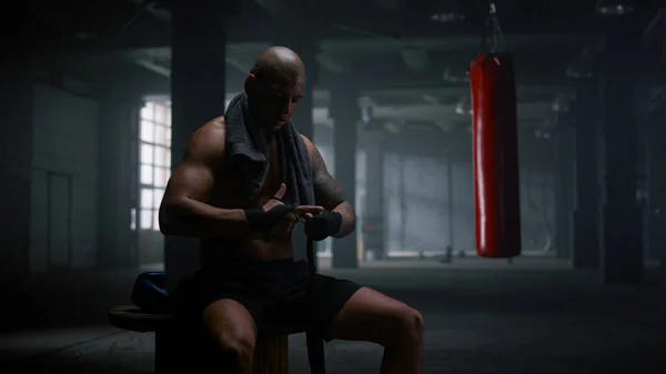 Boxer a enrolar as mãos em fitas de boxe. Esportista focado usando envoltórios de perfuração — Fotografia de Stock