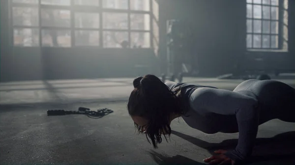 Vrouw op de plank. Atletisch meisje doet push-ups in sport club — Stockfoto