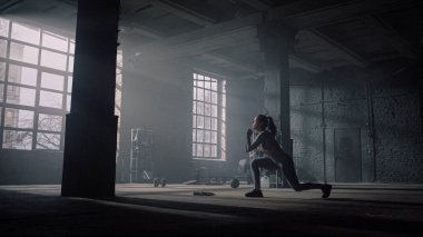 Kız spor kulübünde egzersiz yapıyor. Atlet hamlelerle çömeldi 