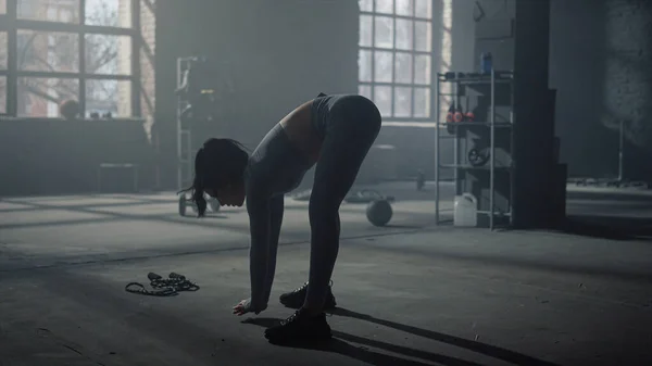 Жінка нахиляється вперед під час тренувань у спортзалі. Фітнес дівчина розтягує тіло — стокове фото