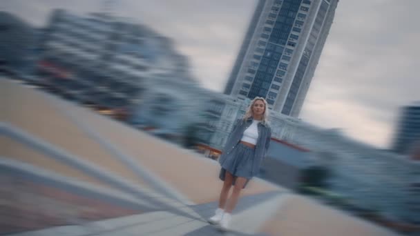 Jonge vrouw staande stad bij zonsondergang in stedelijk gebied moderne architectuur. — Stockvideo