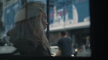 Şehir merkezindeki caddede toplu taşıma istasyonunda oturan kız.. 