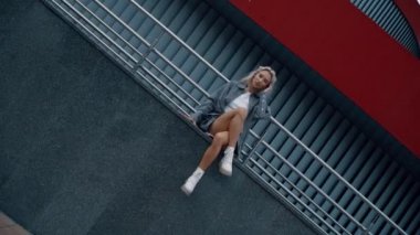 Modern mimari binasında şehir modasında oturan seksi kadın.. 