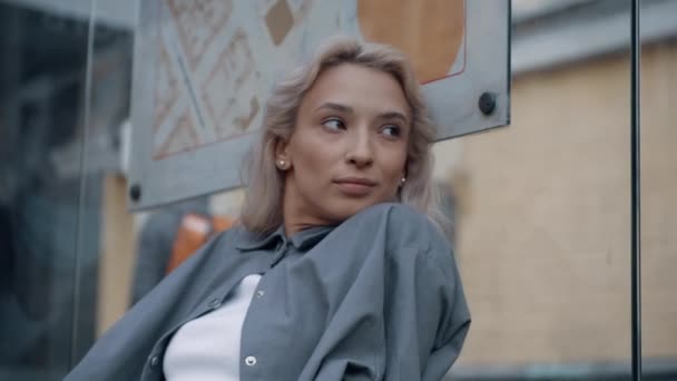 Nenucené dívka autobusové nádraží čeká na jízdu ve velkém městě pozadí. — Stock video