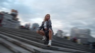 Şehir merkezindeki akşam caddesinde kendine güvenen bir kadın poz veriyor..