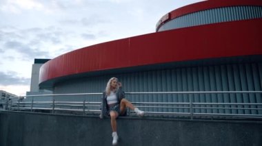 Şehir merkezinde şehir merkezinde sıradan kıyafetlerle oturan sportif kız..