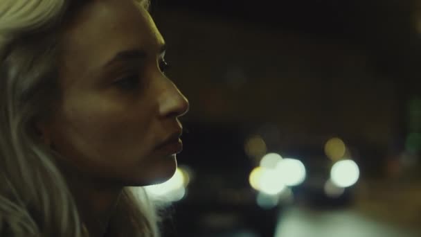 Vrouwelijk gezicht ogende stad met auto 's rijden straat in de late avond. — Stockvideo