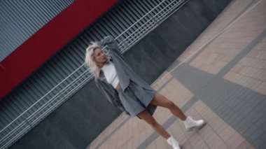 Modern bina kenti yakınlarında sarı saçlı çekici bir model..