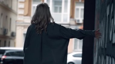 Şehir kızı arabalarla yol kenarındaki modern şehir binasında yürüyor.. 