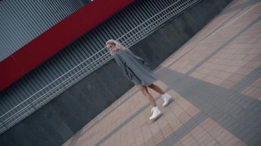 Şehir merkezindeki modern şehir binasının yakınında poz veren model kız..