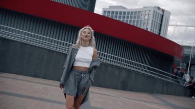 Şehir merkezindeki modern kentsel binaların yakınında yürüyen seksi kadın..