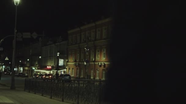 Rento nainen kävelee myöhään yöllä kaupungin keskustassa kadulla. — kuvapankkivideo