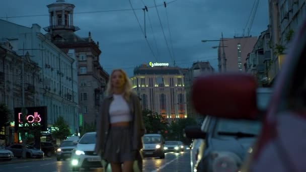 Vrouw model lopen in de richting van camera 's' s avonds stad verkeerslichten. — Stockvideo