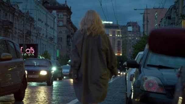 Mujer marchándose de la ciudad nocturna con coches pasando por luces de carretera oscuras. — Vídeos de Stock