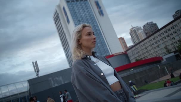 Mooi meisje op zoek uitzicht op stadsgezicht bij schemering avond in stedelijk gebied. — Stockvideo