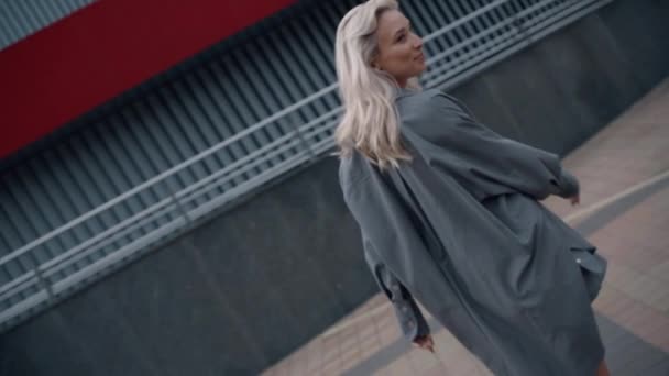 Radostná žena model pózování v ležérní oblečení v budovách města. — Stock video