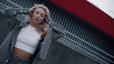 Şehrin modern binasının yakınlarında şehir modasında bir kız model..