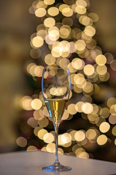 Крупним планом келих для вина на новорічному фоні дерева. Новорічна боке легка текстура — стокове фото