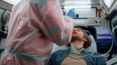 Sağlık ekibi acil servisteki adamın koronavirüsüne geniz temizleme testi yapıyor.