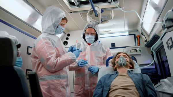 Equipo paramédico multiétnico que sostiene muestras de la prueba del coronavirus en el coche de emergencia —  Fotos de Stock