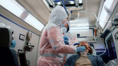 Karışık yarış sağlık görevlileri Coronavirus testi için hastadan burun çubuğu alıyor.